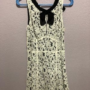 Black sleeveless dress with white lace overlay
